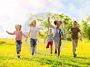 School holidays. Group of children playing with kite outdoors