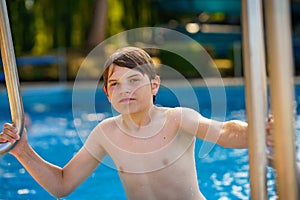 school kid boy ready to swim in the sport swimming pool. outoors on summer day. Sport activities for children. Training