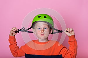 School kid boy skateboarder putting on safety helmet. Responsibility to protect yourself. Child portrait putting on