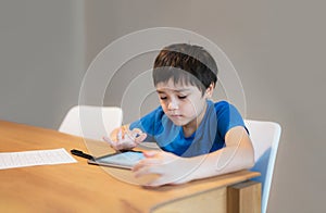 School Kid learning online class room at home, Child using tablet for homework, Young boy studying online video call, E-learning photo