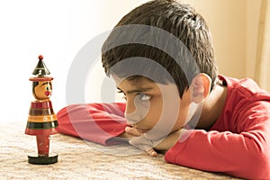 A school kid looking at a wooden toy