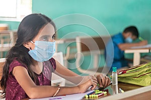 School kid with medical mask listning at classroom - concept of back to school, school reopen with safety measures
