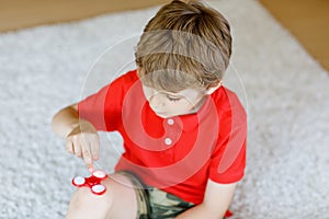 School kid playing with Tri Fidget Hand Spinner indoors
