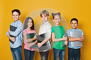 School kids with notebooks over yellow background