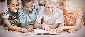 School kids reading book together in library