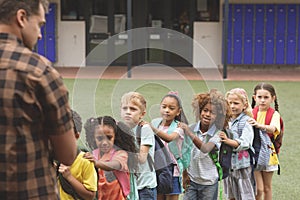 School kids standing in a queue in the schoolyard