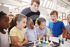 School kids and teacher watch experiment at a science centre