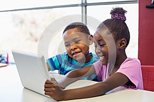 School kids using a digital tablet in classroom