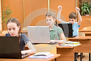 School kids using laptop at lesson