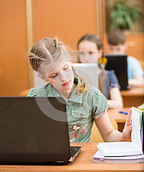 School kids using laptop at lesson