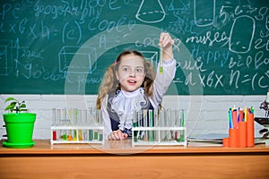 School lesson. Interesting approach to learn. Girl cute school pupil play with test tubes and colorful liquids. School