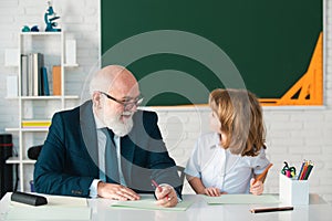 School lessons. Education and learning. Old teacher with pupil in classroom.