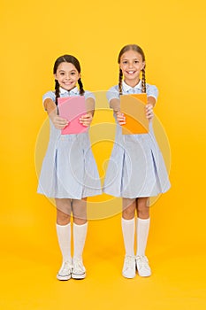 School library. Homeschooling concept. Literacy club. Cute children holding books on yellow background. Little girls