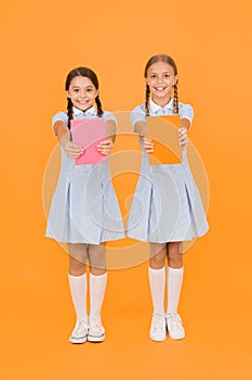 School library. Homeschooling concept. Literacy club. Cute children holding books on yellow background. Little girls