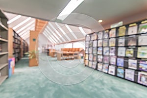 School library or study class room, education blur interior background with blurry view of books on bookshelves in classroom aisle