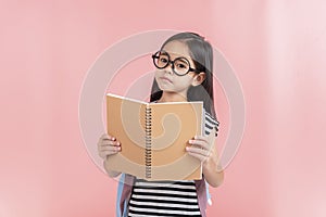 School little girl wearing a glasses carry a bag with backpack hold a books isolated on Pink background