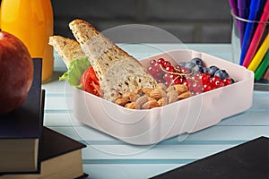 School lunch in a box, berries, nuts and a sandwich. Almonds, red currants and blueberries for a child s snack. Healthy