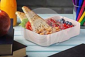 School lunch in a box, berries, nuts and a sandwich. Almonds, red currants and blueberries for a child s snack. Healthy photo