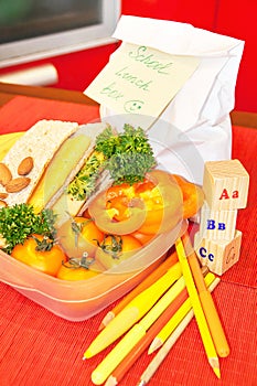School lunch box with paper bag and postie surprise message.
