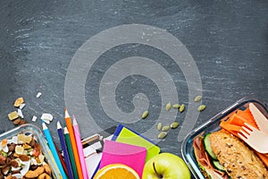 School lunch box with sandwich, fruits, vegetables, nuts and stationery