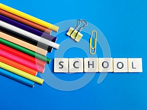 School made of square letter tiles against blue background.