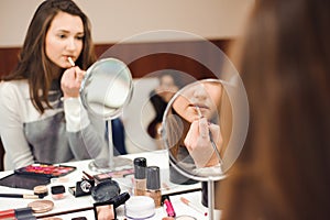 School of makeup. Make up artist doing professional make up of young woman.