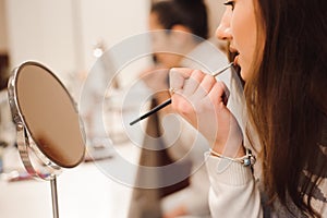 School of makeup. Make up artist doing professional make up of young woman.