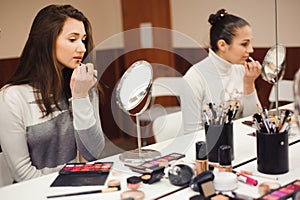 School of makeup. Make up artist doing professional make up of young woman.