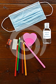 School materials a mouth mask and  liquid hand sanitizer