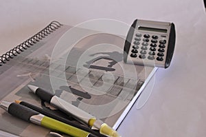 School notebook, with calculators and pens and pencils, in zoom photo with selective focus