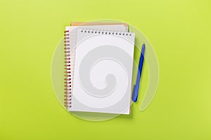 School notebook on a green background, spiral notepad on a table