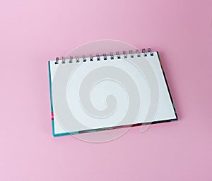 school notebook on pink background, spiral notebook close-up