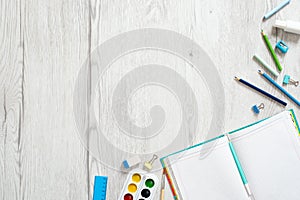 School notebook and various stationery on wooden background. Back to school concept. Flat lay, top view, overhead