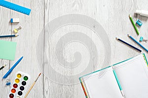 School notebook and various stationery on wooden background. Back to school concept. Flat lay, top view, overhead