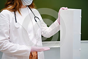 School nurse showing an ultraviolet lamp in a casing for air disinfection in a classroom. The problem with lessons in the