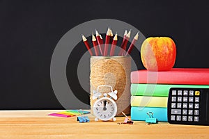 School and office supplies on a black chalkboard background. Back to school.