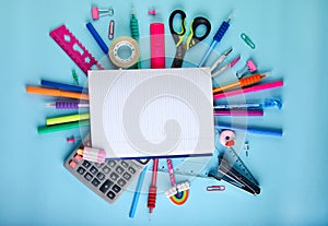 School office supplies on a blue background with copy space. Back to school