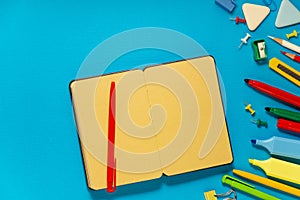 School office supplies on a desk with copy space. Back to school concept. School supplies on blue background. Back 2 school