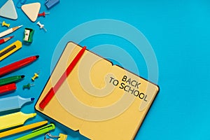 School office supplies on a desk with copy space. Back to school concept. School supplies on blue background. Back 2 school