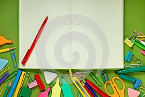 School office supplies on a desk with copy space. Back to school concept. School supplies on green background. Back 2 school