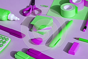 School and office supplies on a purple-green background