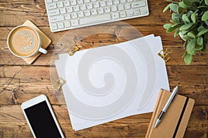 School paper with coffee cup, smartphone and plant on wooden table. Top view from above