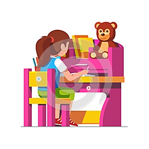 School girl studying sitting at pink child desk