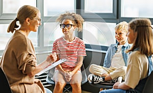 School psychologist with a group of  children conducts a mental health lesson, group therapy, a psychotherapy session