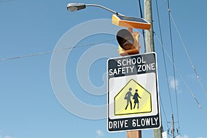 school safety zone drive slowly sign with illustration of people walking. p