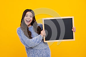 School sales board. Cheerful teenage girl kid hold blackboard chalkboard with copy space. Amazed teenager. Excited teen