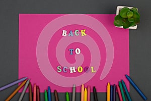 School set with pink paper, text & x22;Back to school& x22; of wooden letters and crayons