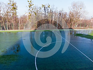 School soccer field covered with melted water from melting snow