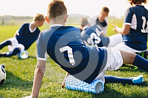 School Soccer Stretching Session. Young Footballers Using Foam Rollers