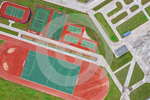 School sports ground with football stadium, jogging tracks around. basketball, volleyball, tennis courts. aerial photo